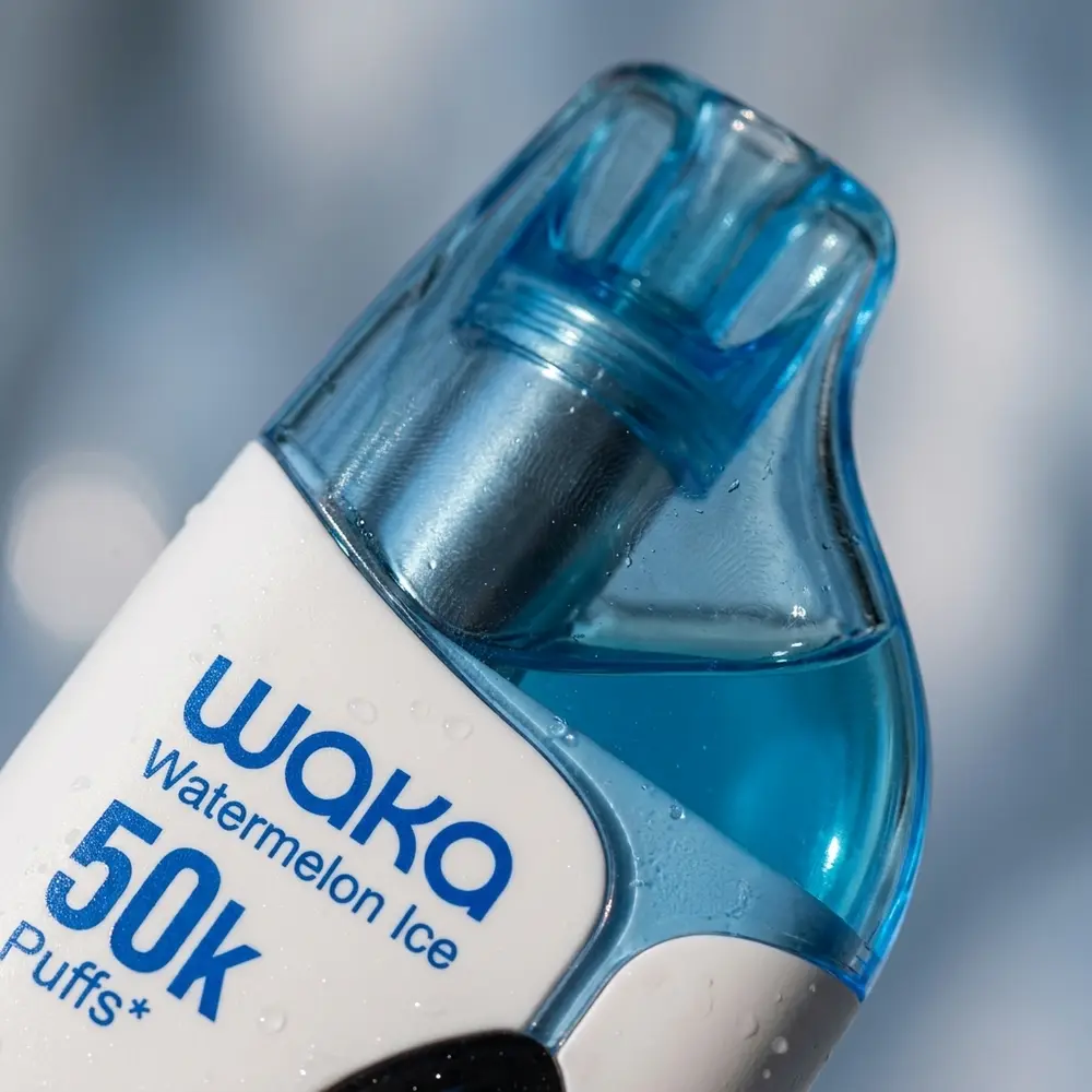 Macro do bocal e logo do Waka Iken com gotas de condensacao, reflexos metalicos e textura tactil - Vapor Gringo
